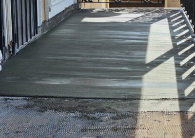 a concrete patio with a fence and a door